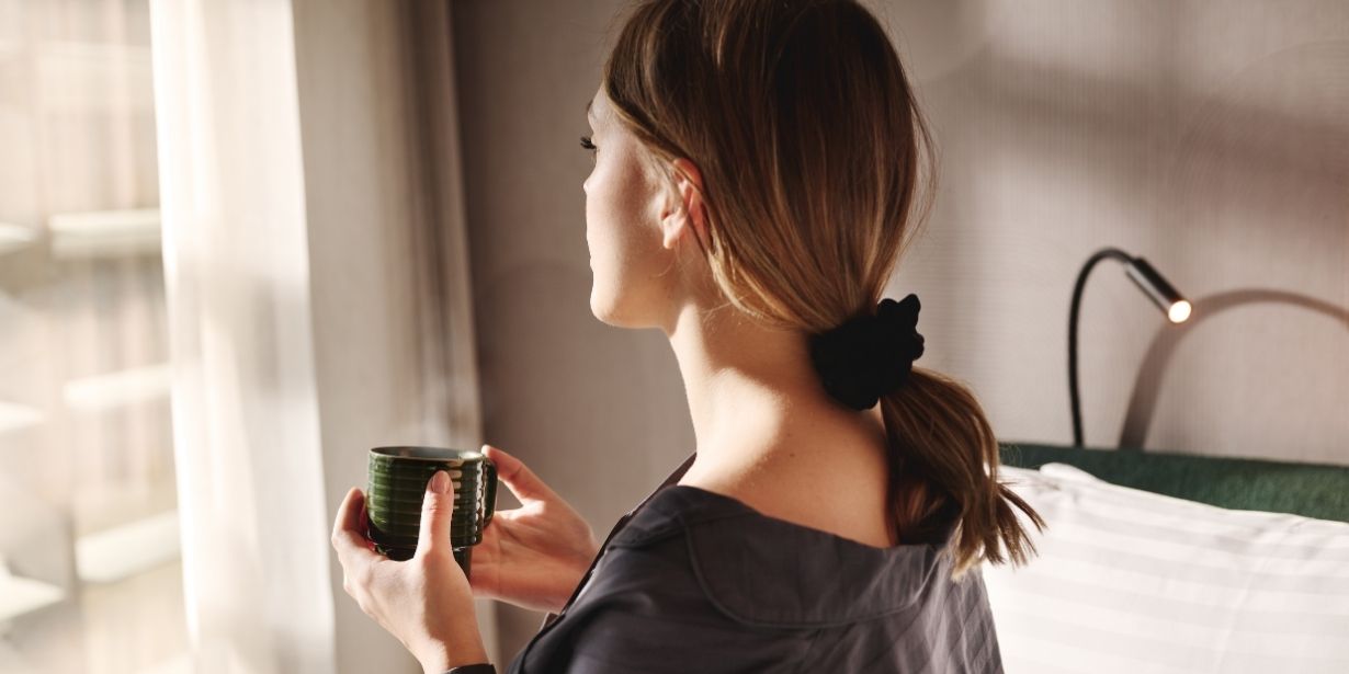 Guest enjoying a long stay in a modern hotel room at the Wellington Glasgow, relaxing by the window with a coffee